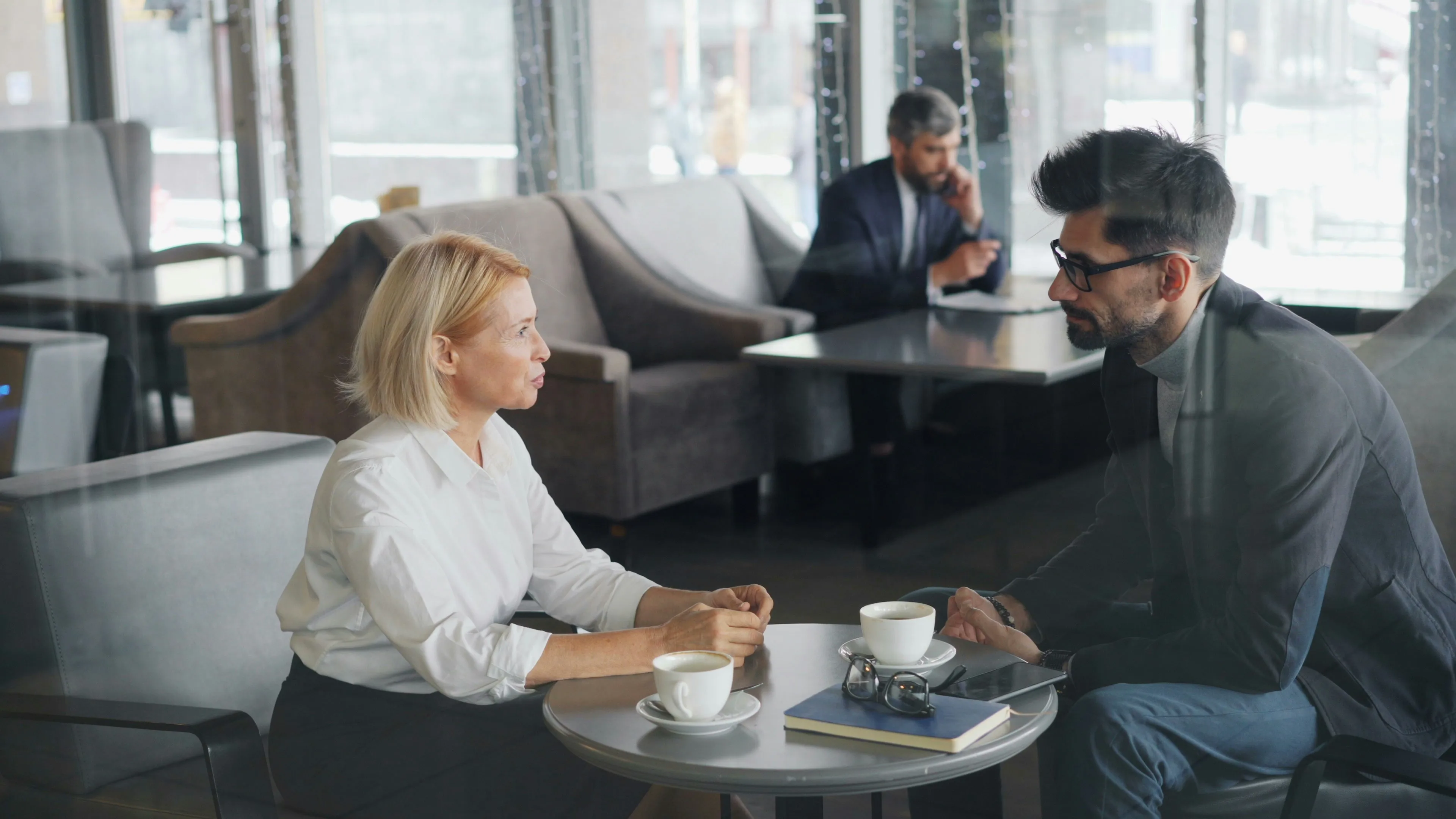 Führungskraft gibt Mitarbeiter bei einem gemeinsamen Kaffee Feedback